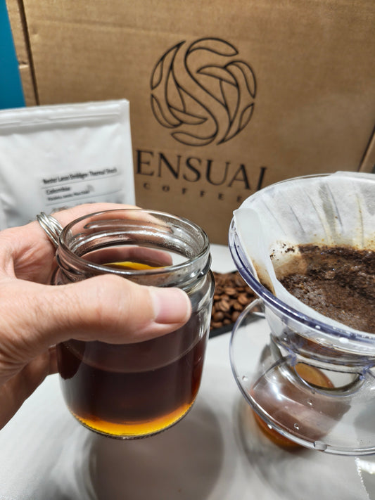 Coffee Equipment in the background why I hold my brewed specialty coffee in my hands.