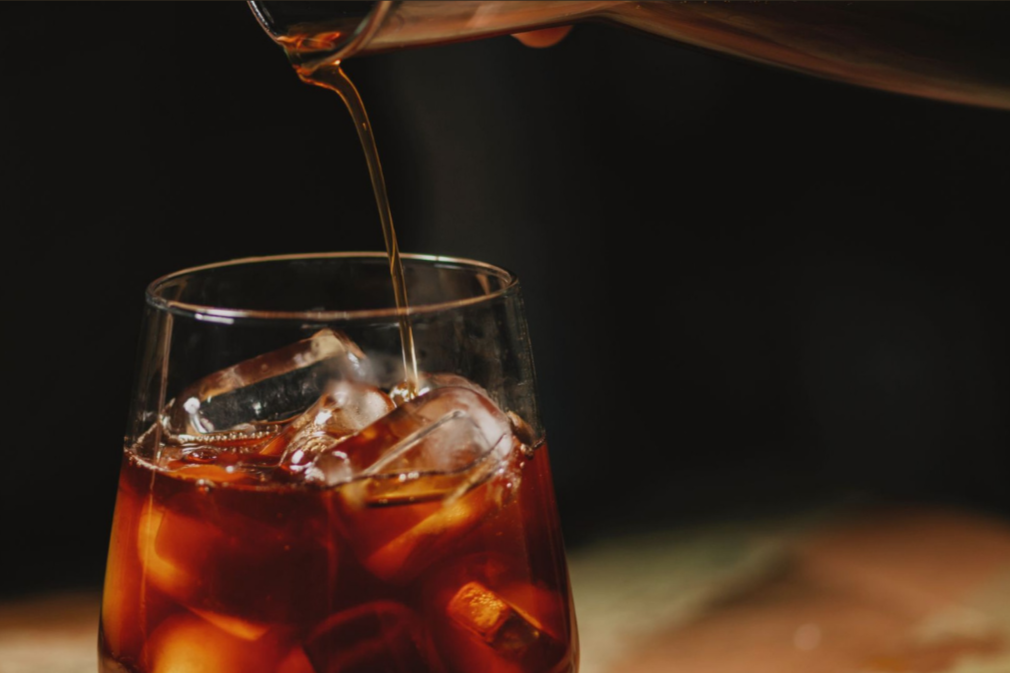 Sensual Coffee with a glass of iced cold brew being poured.