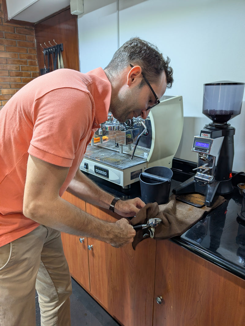 Man cleaning a Stamp in front of the Coffee machine