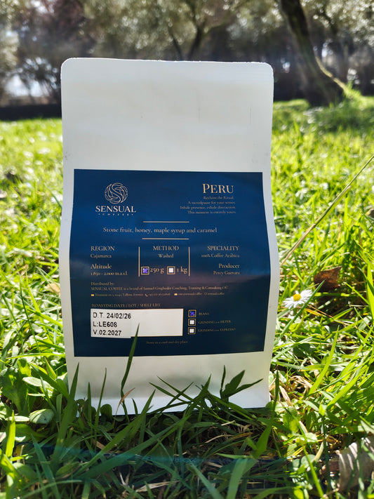 Coffee bag labeled 'Peru' by Sensual Coffee Roasters on grass